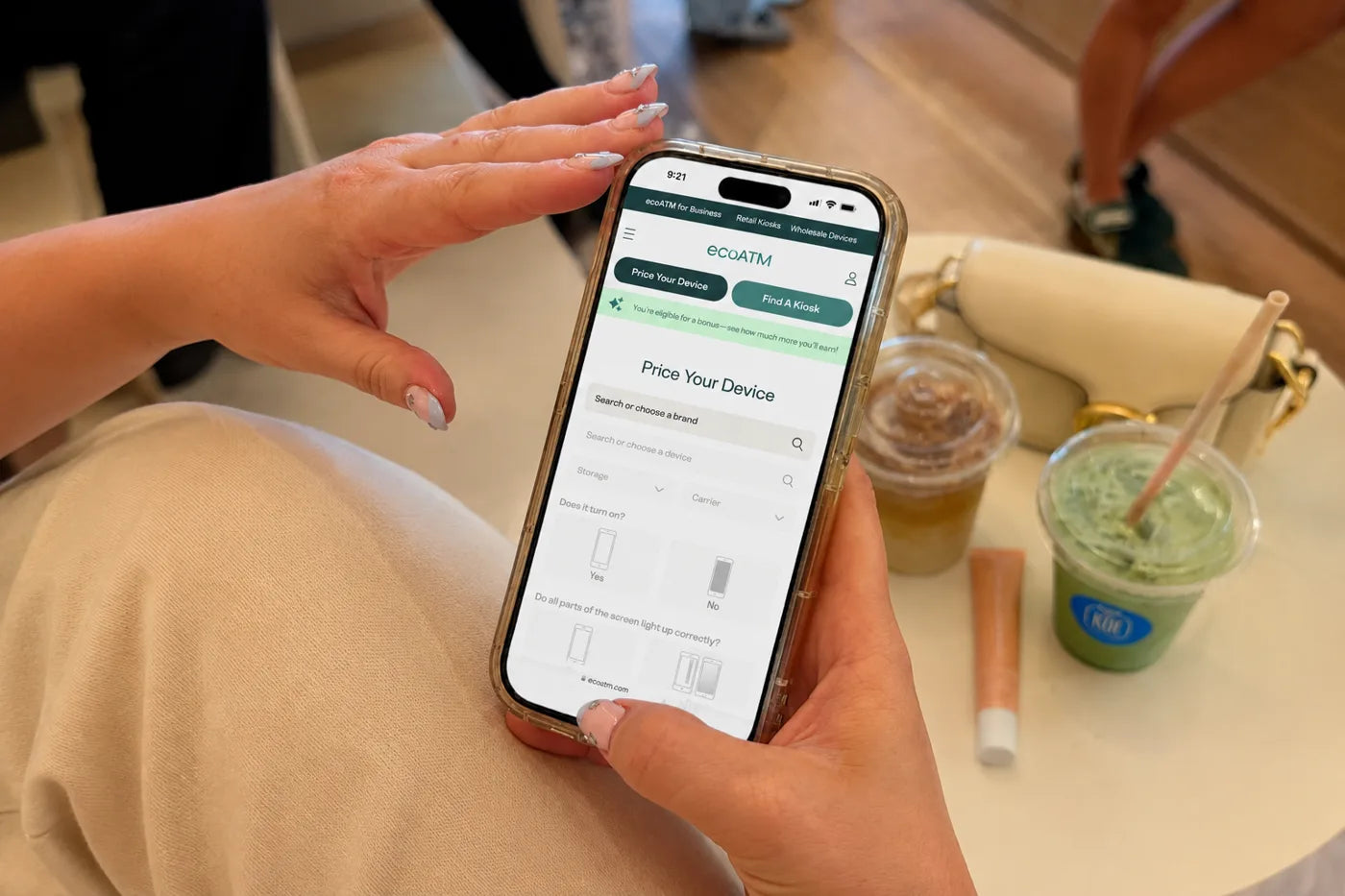 A hand holding a phone open to the ecoATM Price Your Device page